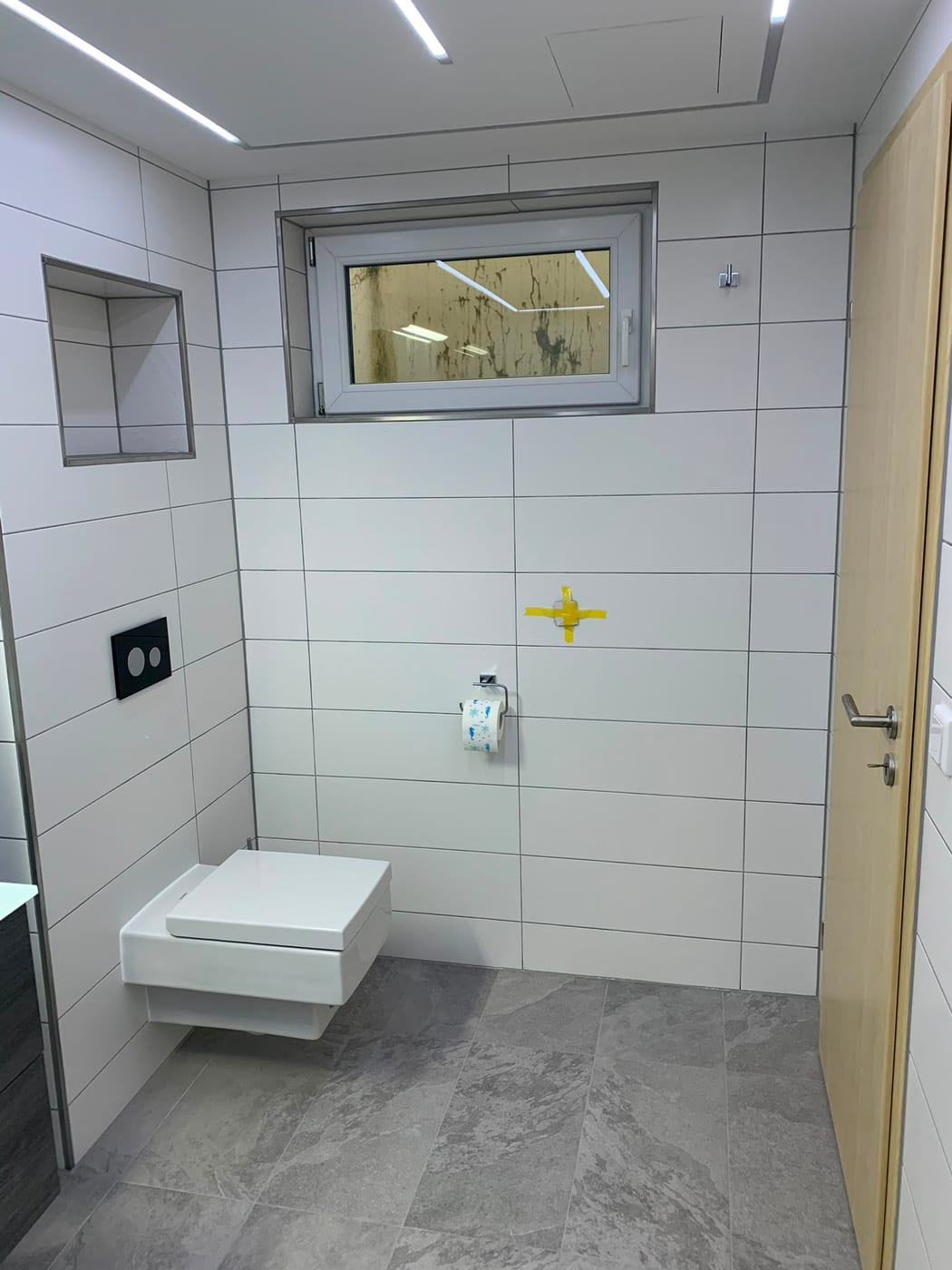Fertiges Badezimmer mit Wandnische, Wand-WC und Marmoroptik-Boden