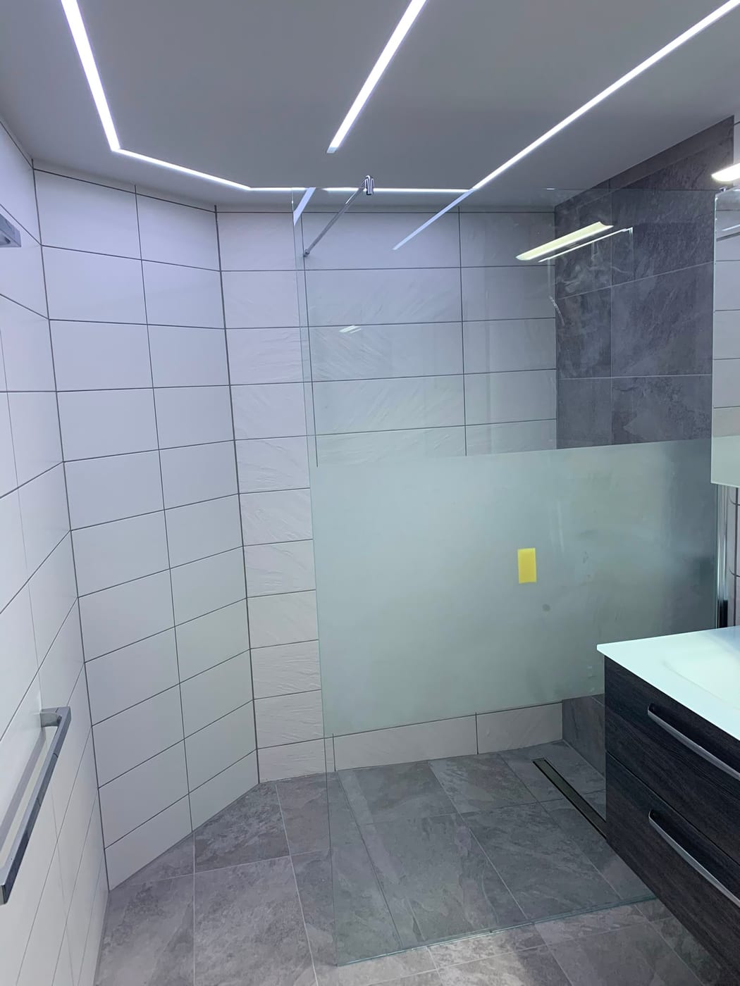 Bodengleiche Walk-in-Dusche mit Glastrennwand und Schieferoptik-Wand